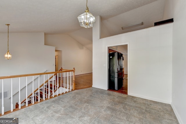 unfurnished room with an inviting chandelier, vaulted ceiling, and wood-type flooring