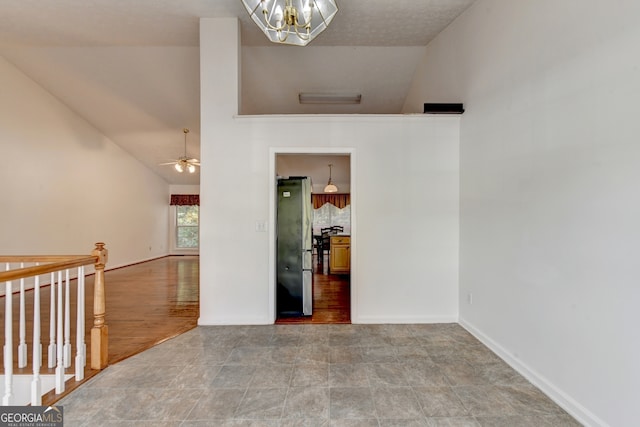 unfurnished room featuring wood-type flooring, ceiling fan with notable chandelier, and lofted ceiling