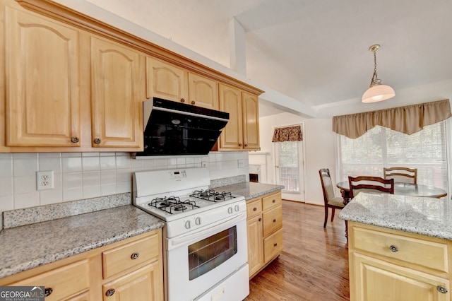 kitchen featuring light brown cabinets, light stone countertops, pendant lighting, light wood-type flooring, and white range with gas stovetop