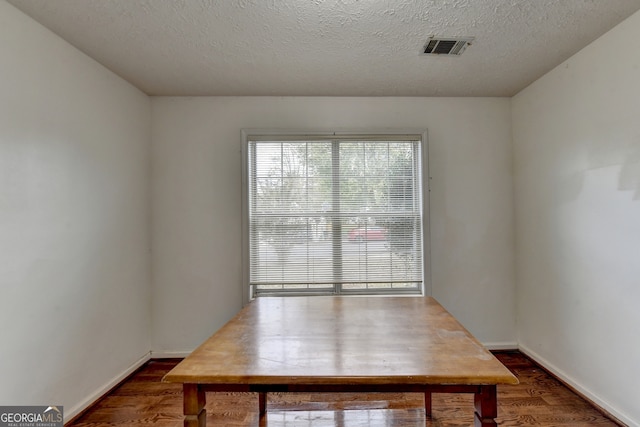 dining area featuring dark hardwood / wood-style floors and a textured ceiling