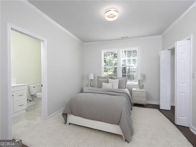 bedroom with ornamental molding, ensuite bath, and hardwood / wood-style flooring