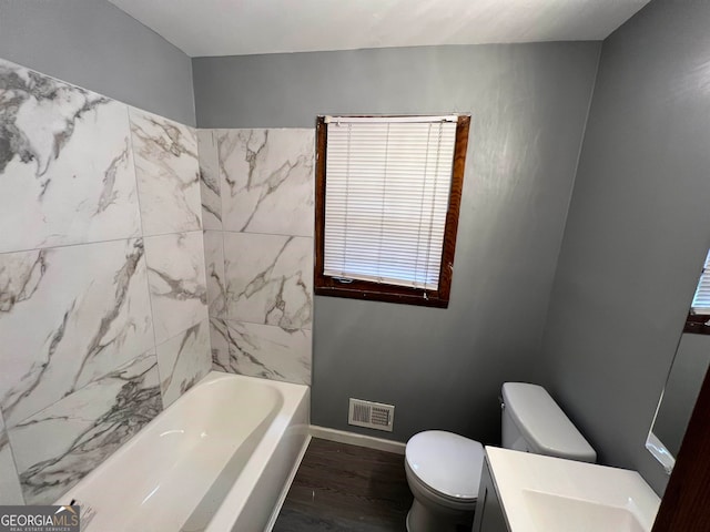 bathroom with toilet, a bathtub, vanity, and hardwood / wood-style flooring