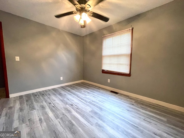 empty room featuring wood-type flooring, a textured ceiling, and ceiling fan