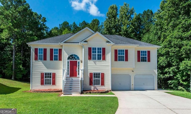 raised ranch featuring a garage and a front yard