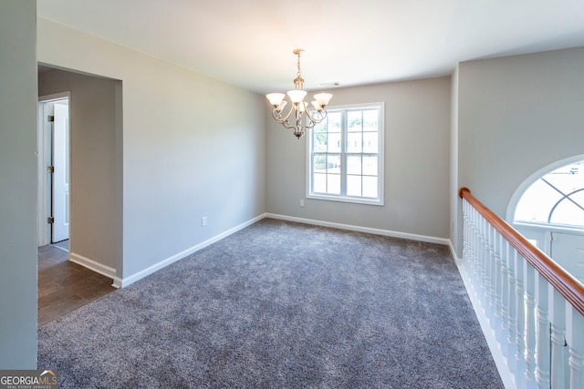 carpeted empty room with a chandelier