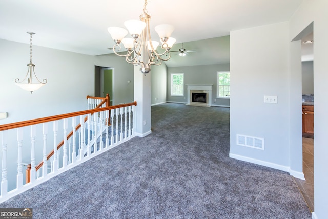 carpeted spare room featuring a chandelier