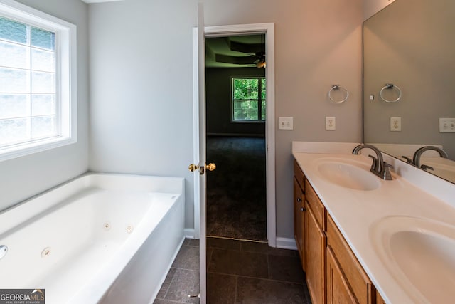 bathroom featuring vanity, a bath, plenty of natural light, and tile patterned floors