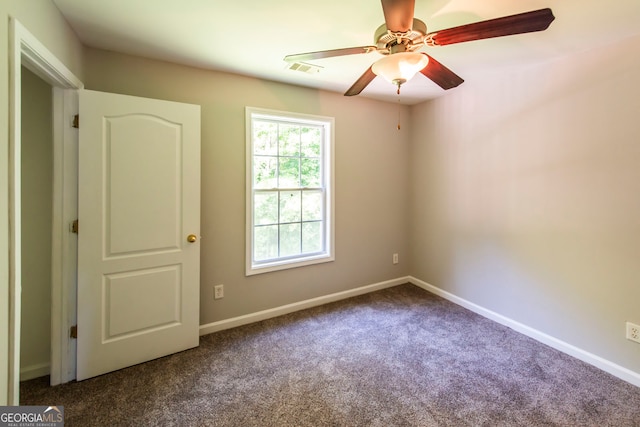 empty room with ceiling fan and carpet floors