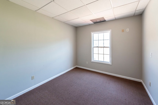 unfurnished room with carpet flooring and a paneled ceiling