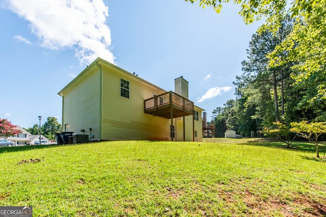 rear view of house featuring a lawn and central AC