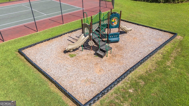 view of play area featuring tennis court and a lawn