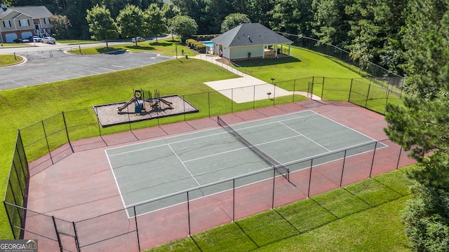 view of tennis court with a yard