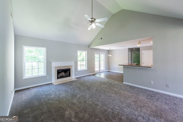 unfurnished living room with high vaulted ceiling, dark colored carpet, and ceiling fan