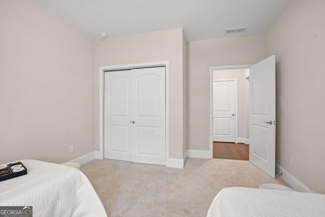 bedroom with a closet and light colored carpet