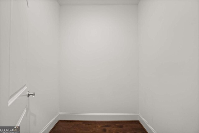 unfurnished room with dark wood-type flooring