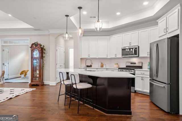 kitchen featuring dark hardwood / wood-style flooring, sink, decorative light fixtures, and appliances with stainless steel finishes