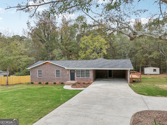 single story home with a front lawn, a storage unit, and a carport