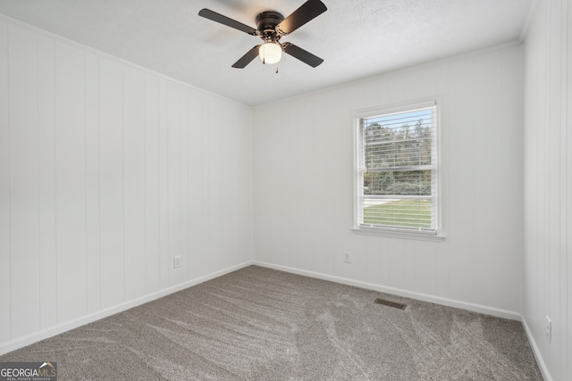 empty room featuring ornamental molding, carpet, and ceiling fan