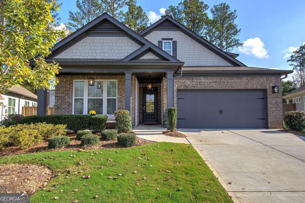 craftsman house featuring a garage and a front lawn