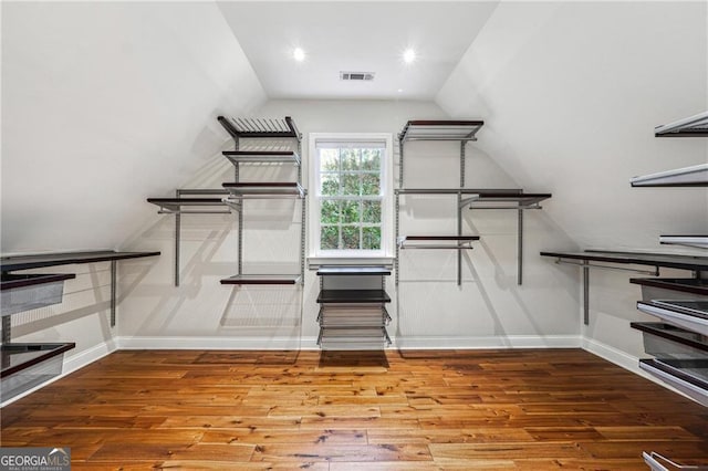 spacious closet featuring hardwood / wood-style floors and vaulted ceiling