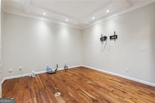 spare room featuring hardwood / wood-style flooring, beam ceiling, coffered ceiling, and ornamental molding