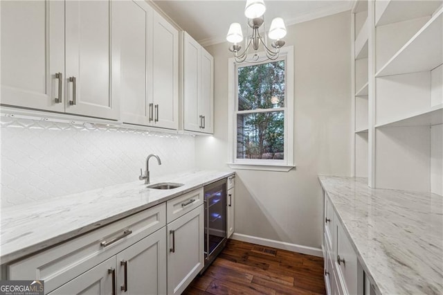 kitchen with ornamental molding, dark hardwood / wood-style floors, light stone countertops, white cabinetry, and wine cooler