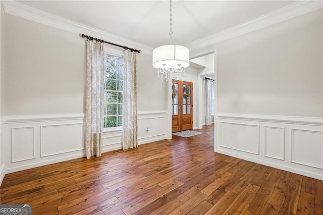 unfurnished dining area with dark hardwood / wood-style flooring, a chandelier, and crown molding