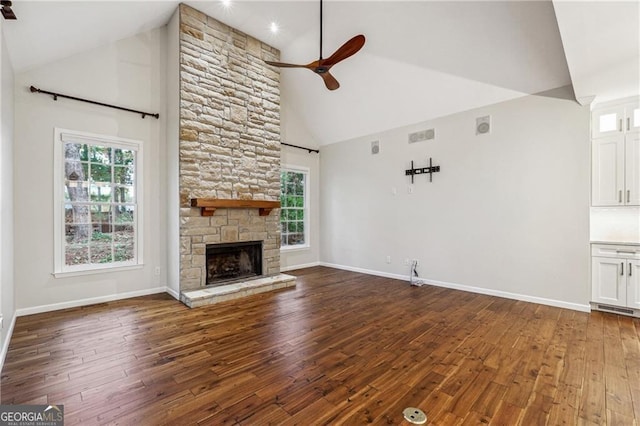 unfurnished living room featuring dark wood-type flooring, high vaulted ceiling, ceiling fan, and a fireplace