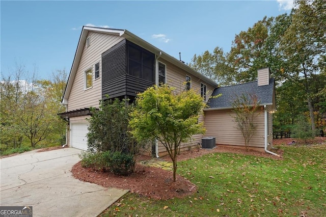 view of property exterior with a garage, cooling unit, and a yard