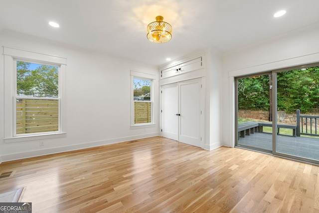 unfurnished living room with ornamental molding and light hardwood / wood-style floors