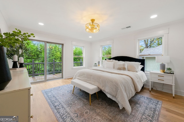 bedroom with multiple windows, wood-type flooring, and crown molding