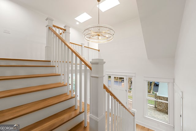 stairs featuring hardwood / wood-style flooring and a chandelier