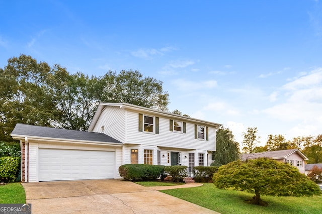 colonial inspired home featuring a garage and a front lawn