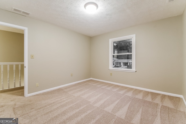 unfurnished room featuring carpet floors and a textured ceiling