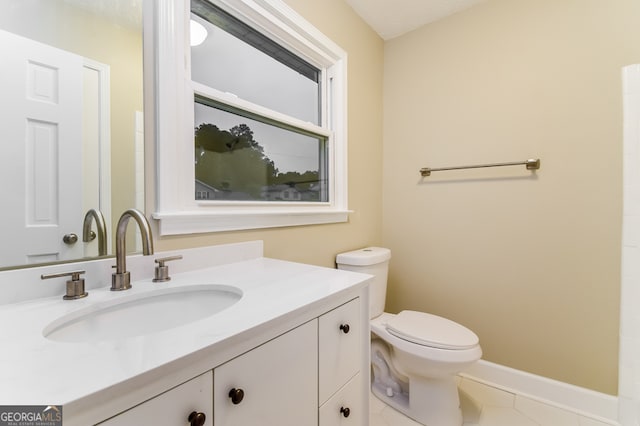 bathroom with tile patterned flooring, vanity, and toilet