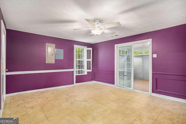 spare room with electric panel, a textured ceiling, and plenty of natural light