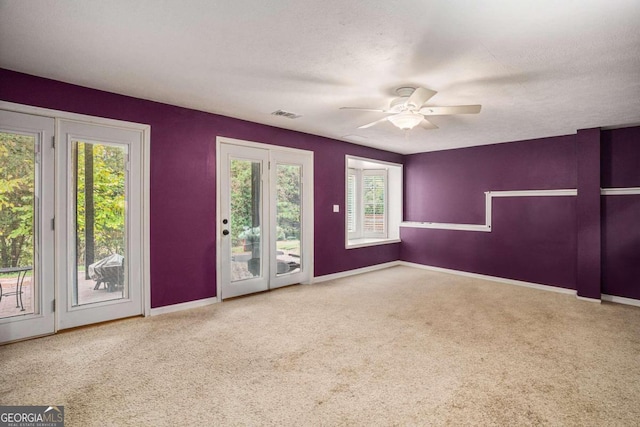 carpeted empty room featuring a textured ceiling and ceiling fan