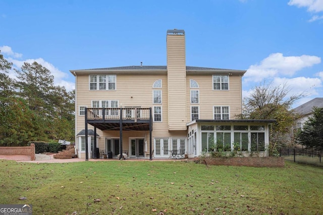 back of property featuring a patio area, a sunroom, a yard, and a wooden deck