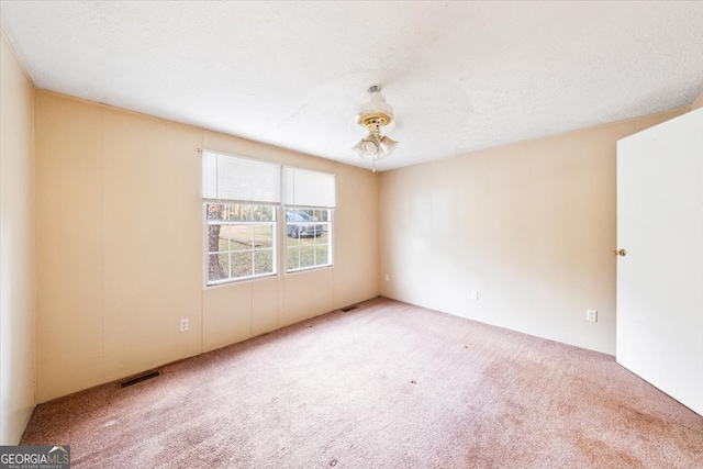 empty room with ceiling fan, a textured ceiling, and carpet flooring