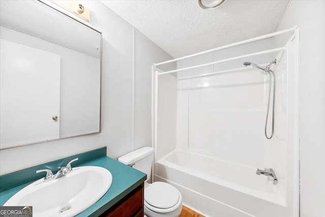 full bathroom featuring vanity, washtub / shower combination, a textured ceiling, and toilet