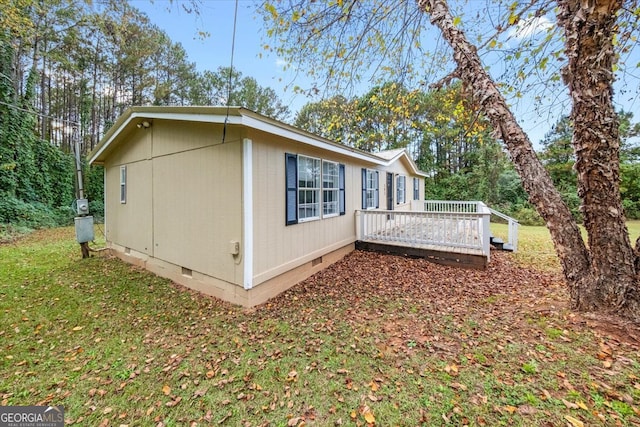 view of home's exterior with a wooden deck and a yard