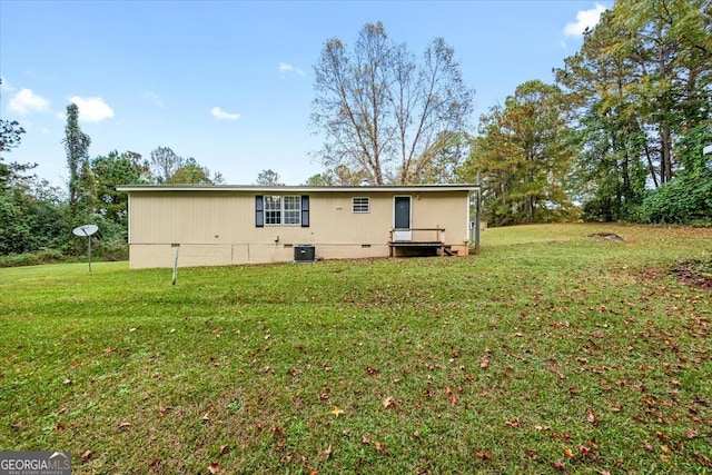 rear view of house with a lawn and central AC