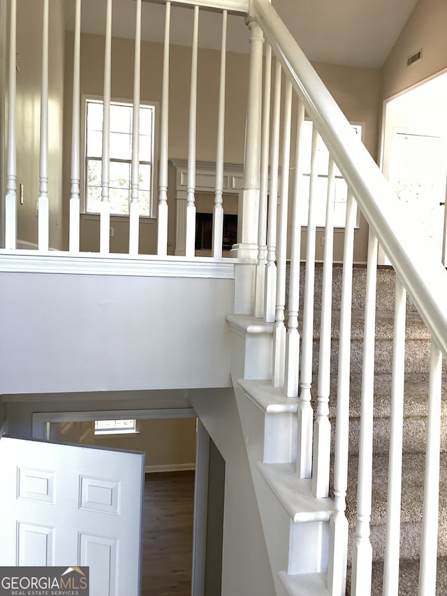 stairs with wood-type flooring and lofted ceiling