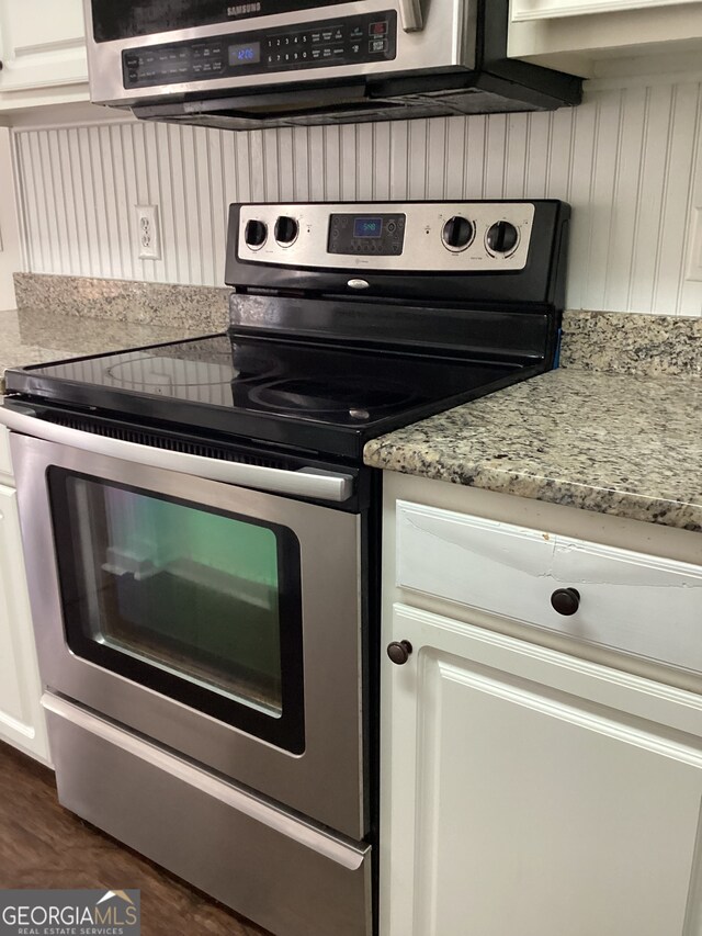 kitchen with extractor fan, light stone countertops, stainless steel range with electric stovetop, white cabinets, and dark wood-type flooring