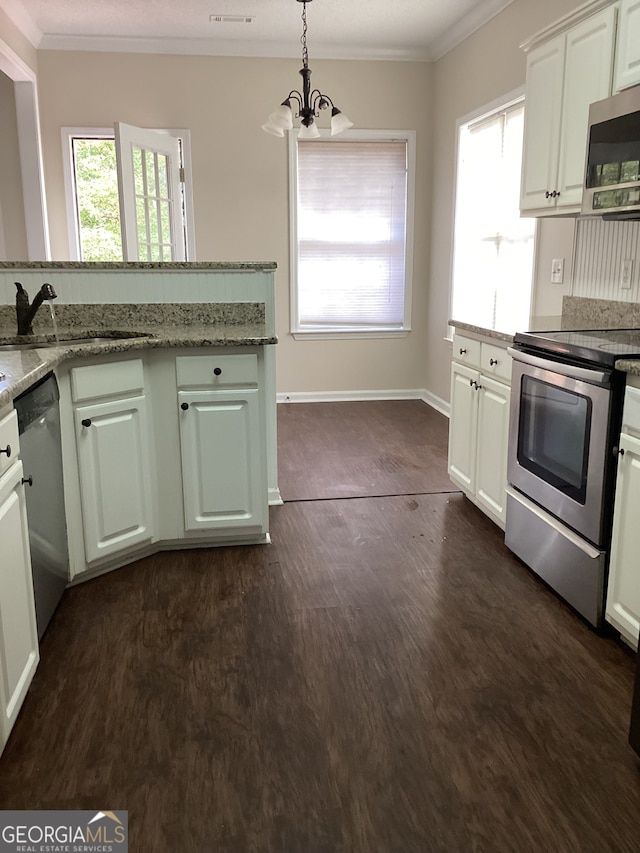 kitchen featuring light stone counters, dark hardwood / wood-style floors, decorative light fixtures, and appliances with stainless steel finishes