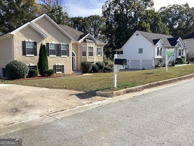 bi-level home featuring a garage and a front yard