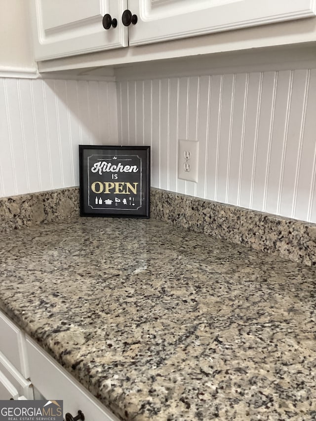 interior details featuring stone counters and white cabinetry