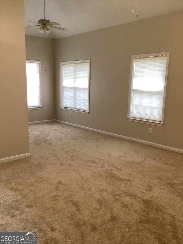 spare room featuring light colored carpet and ceiling fan