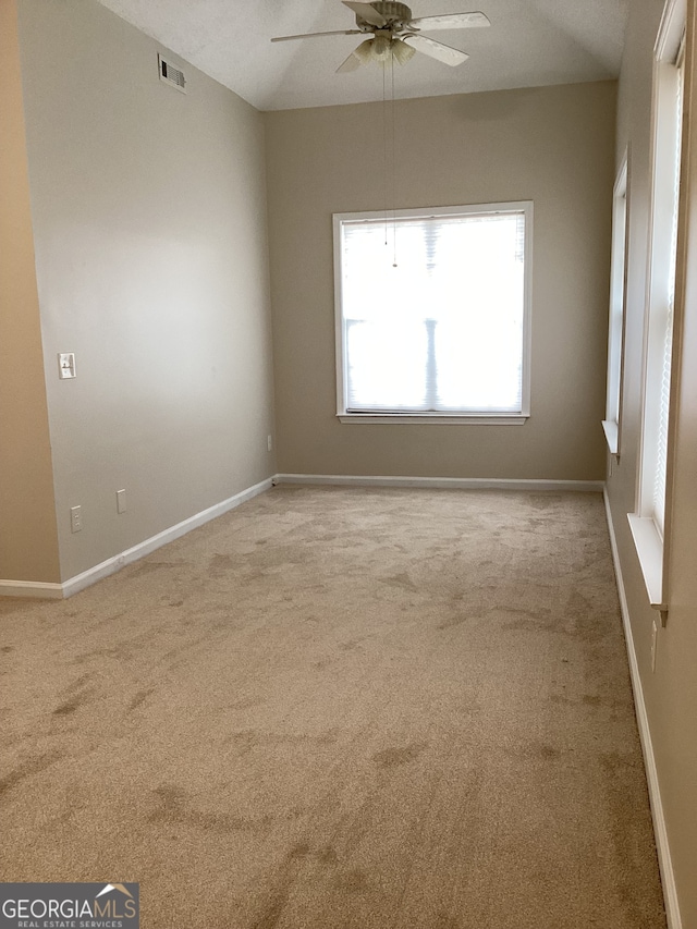 unfurnished room with ceiling fan and light carpet