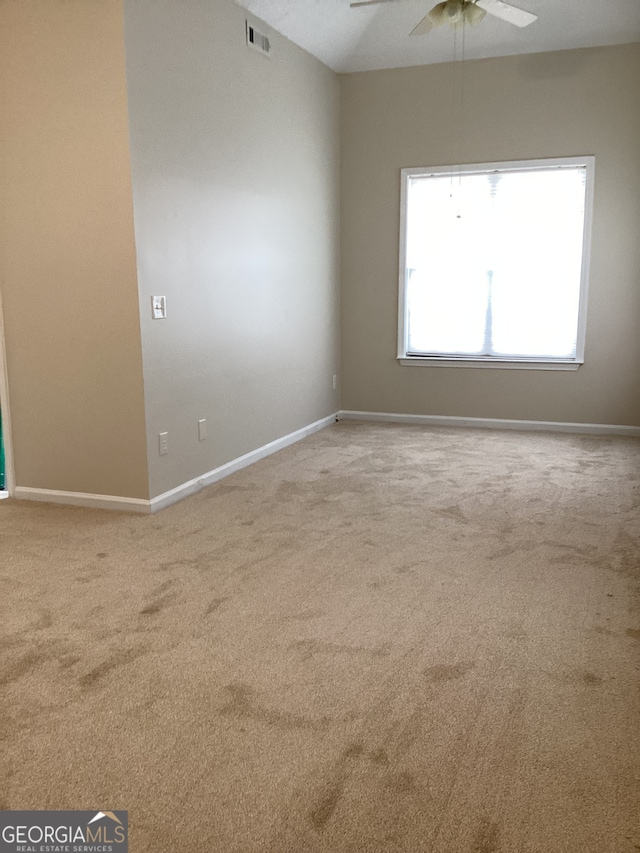 unfurnished room with light colored carpet and ceiling fan